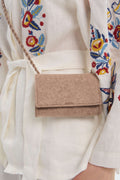 Beige felt mini crossbody bag worn by a person with a colorful floral-patterned garment.