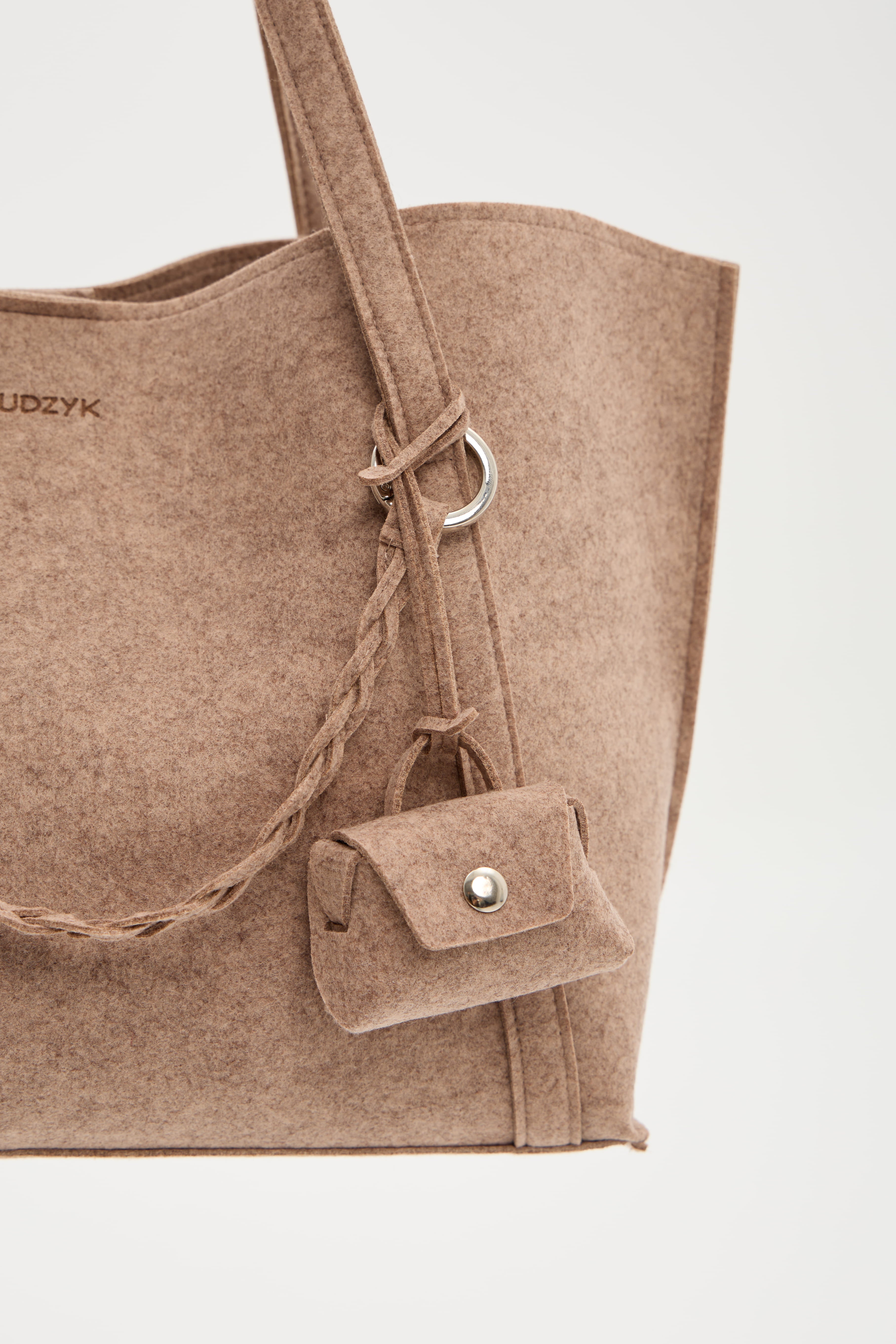 Beige tote bag with a small bag and strap detail on a light gray background