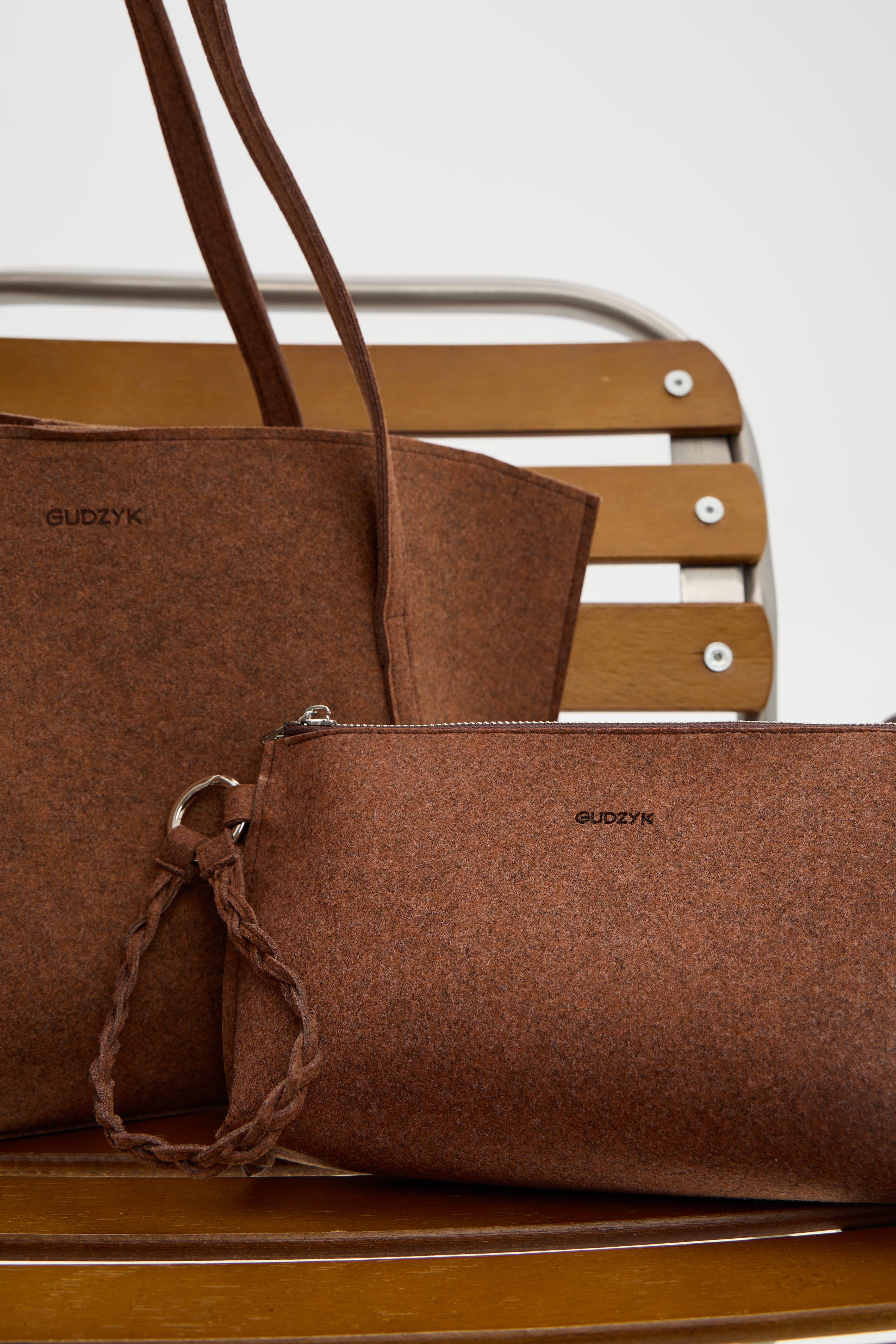 Brown ecofelt handbag with a strap on a wooden surface