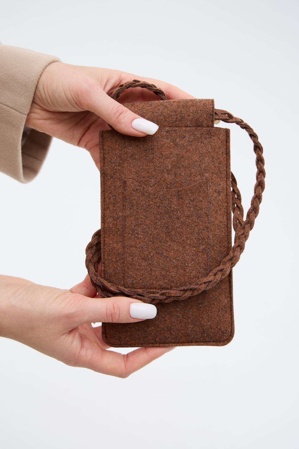 Brown felt phone bag with braided handle held by a person on a white background