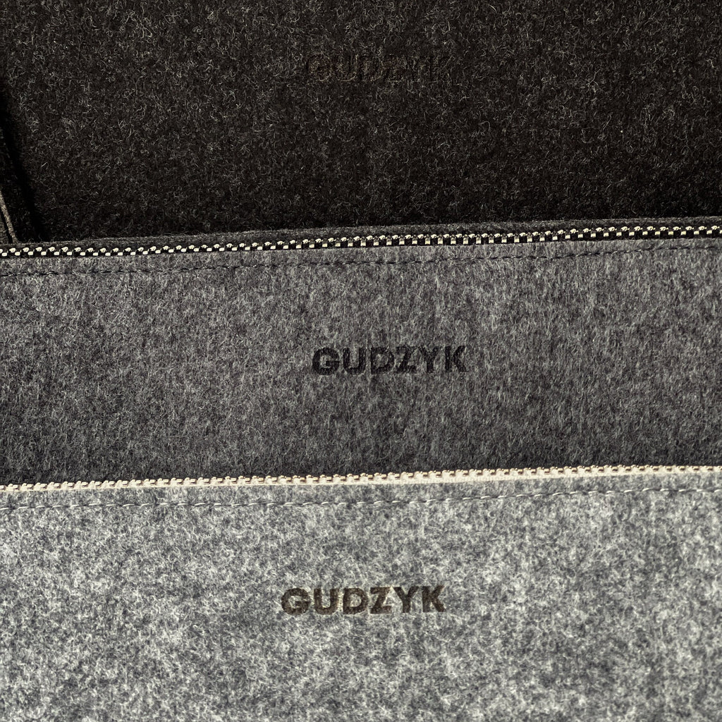 Close-up of a gray felt pouch with 'GUDZYK' branding.