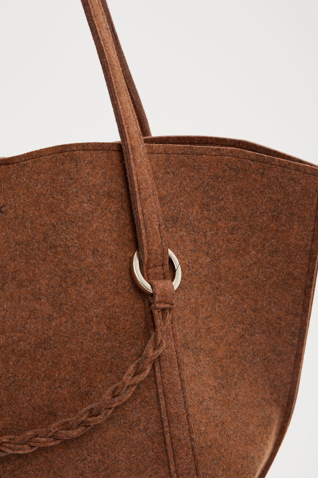 Close-up of a brown bag with a strap on a light gray background