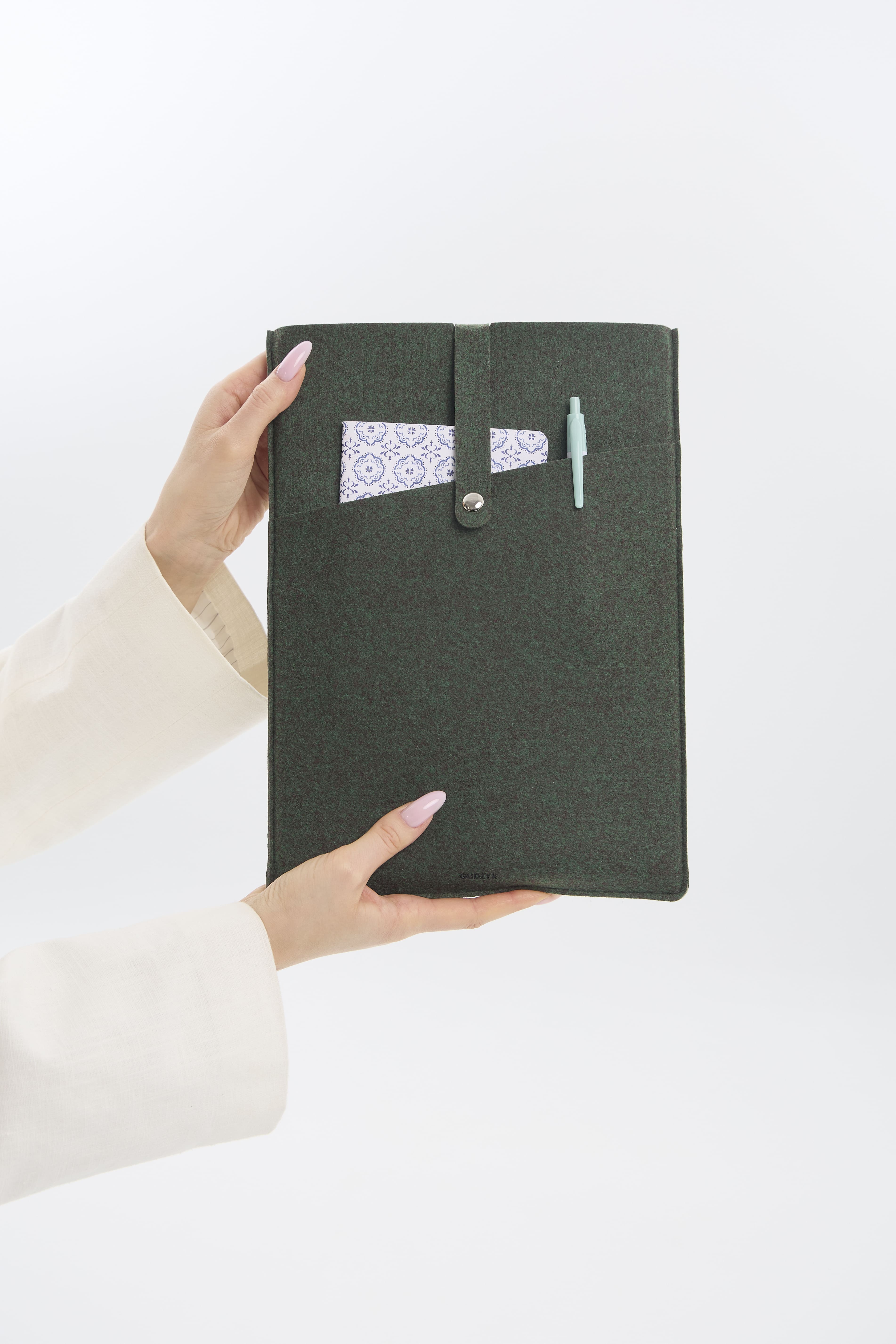 Dark green tablet case held by a person on a white background