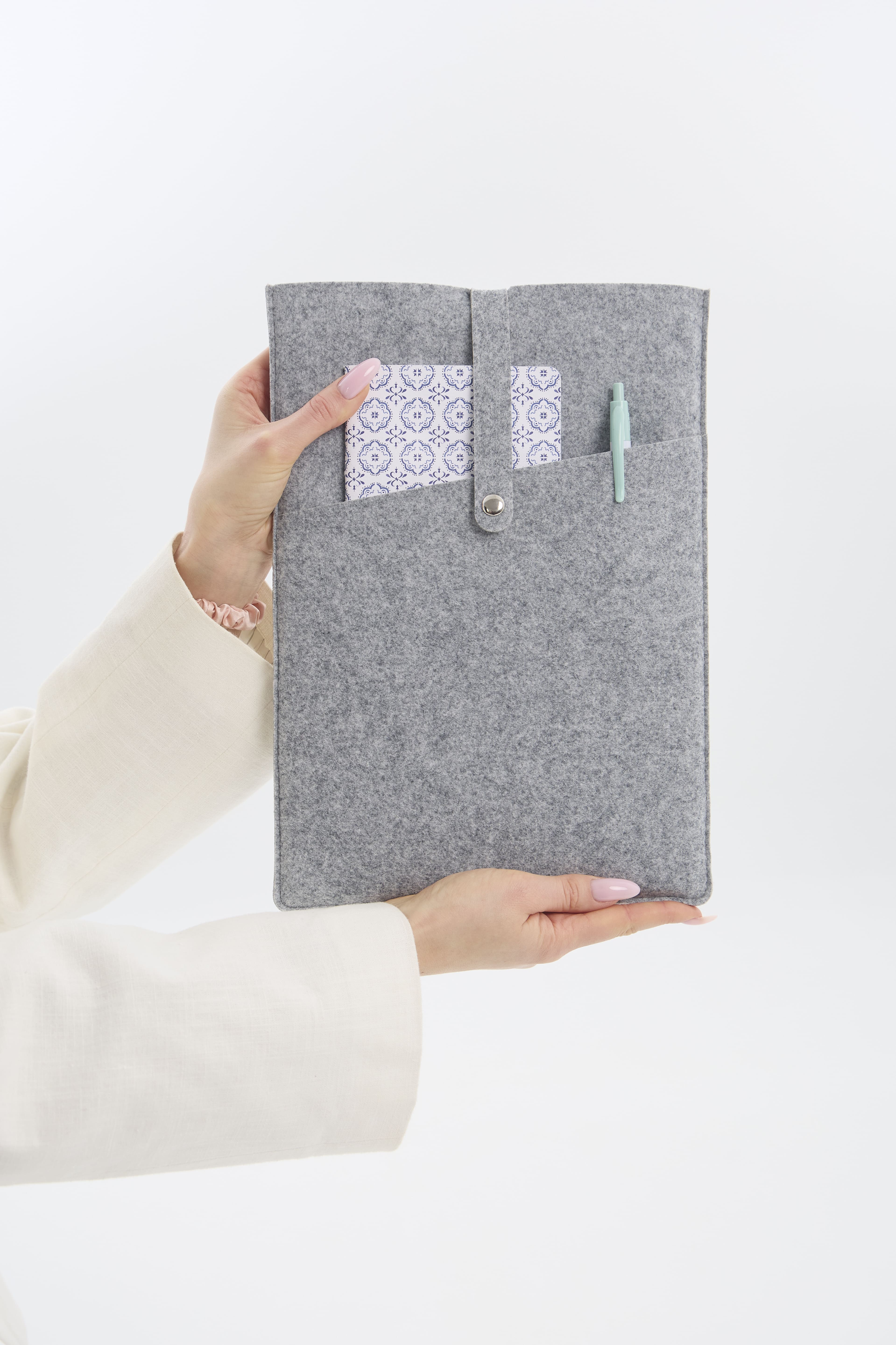 Gray felt tablet sleeve held by a person on a white background