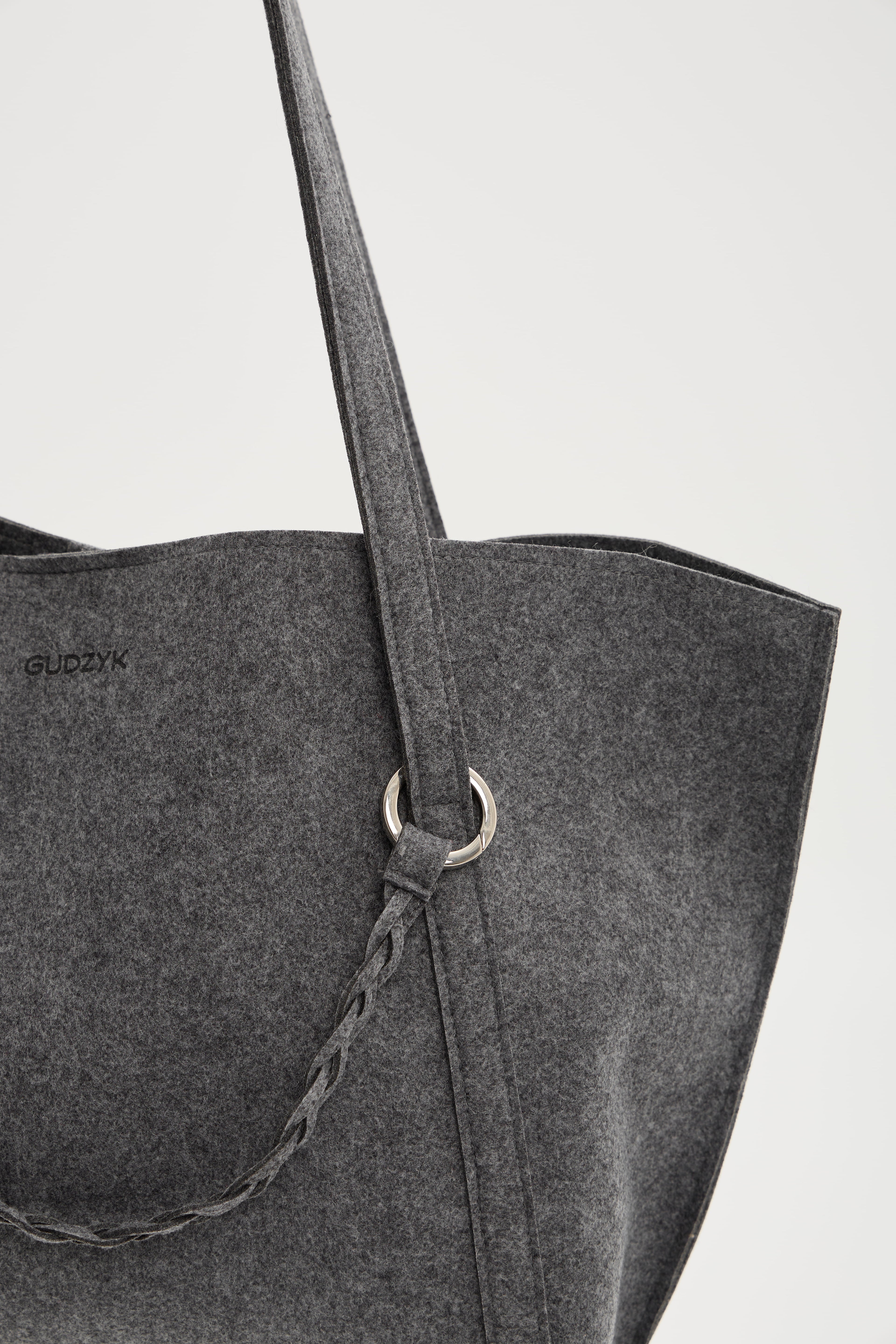Gray tote bag with a strap on a light gray background