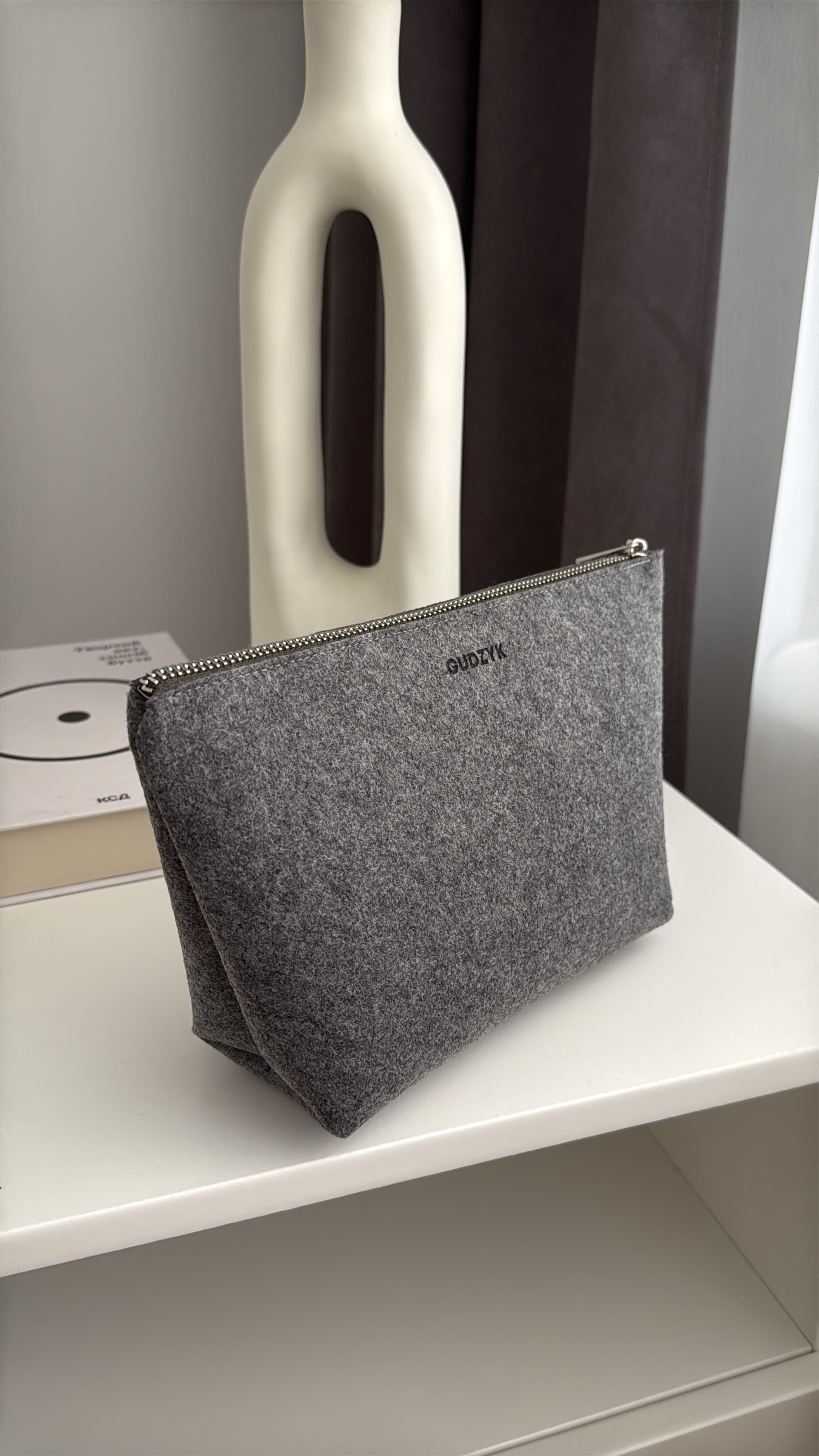Gray pouch on a white surface with a blurred background