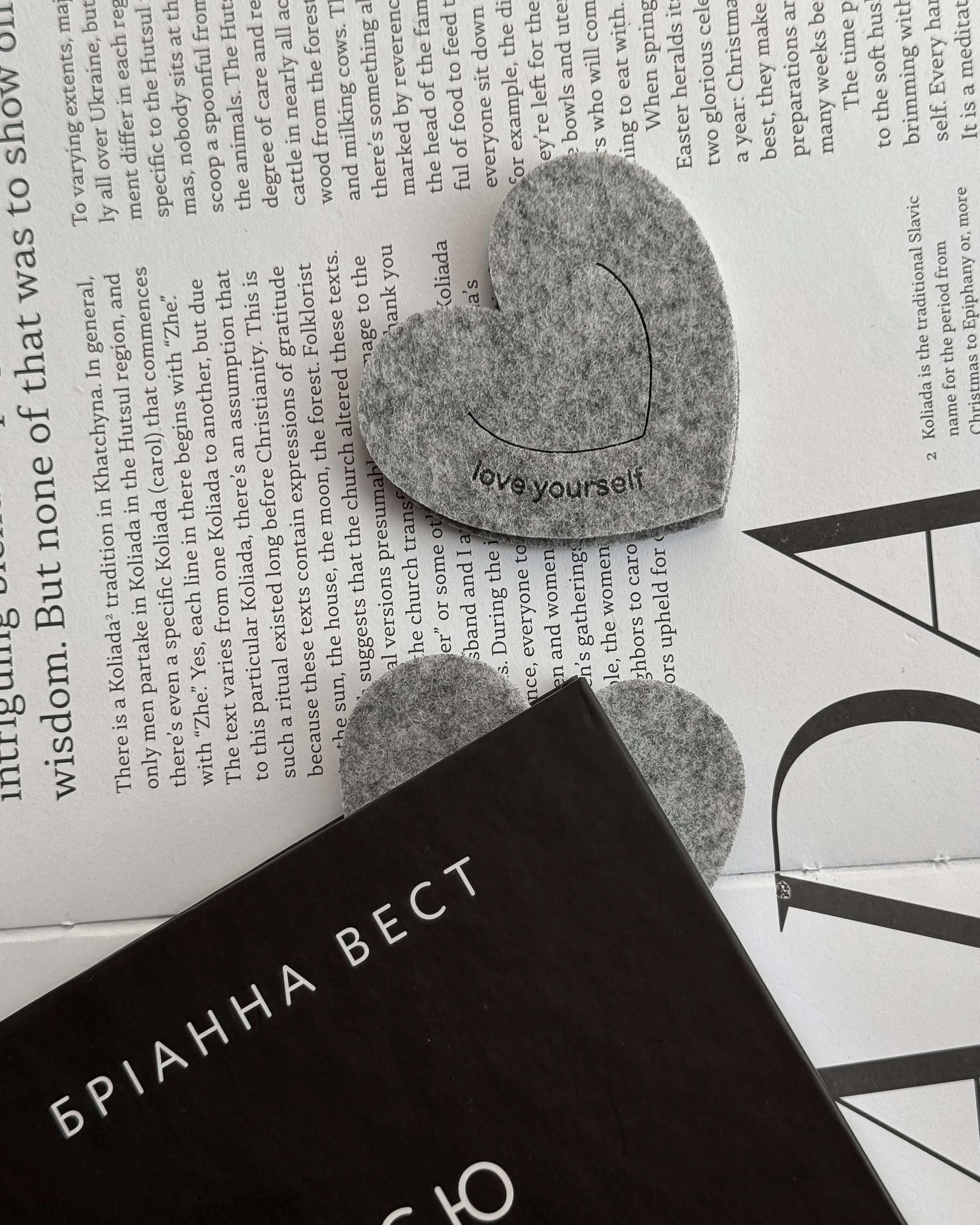 Heart-shaped 'love yourself' object on a book with text