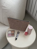 Makeup bag with makeup items on a round table
