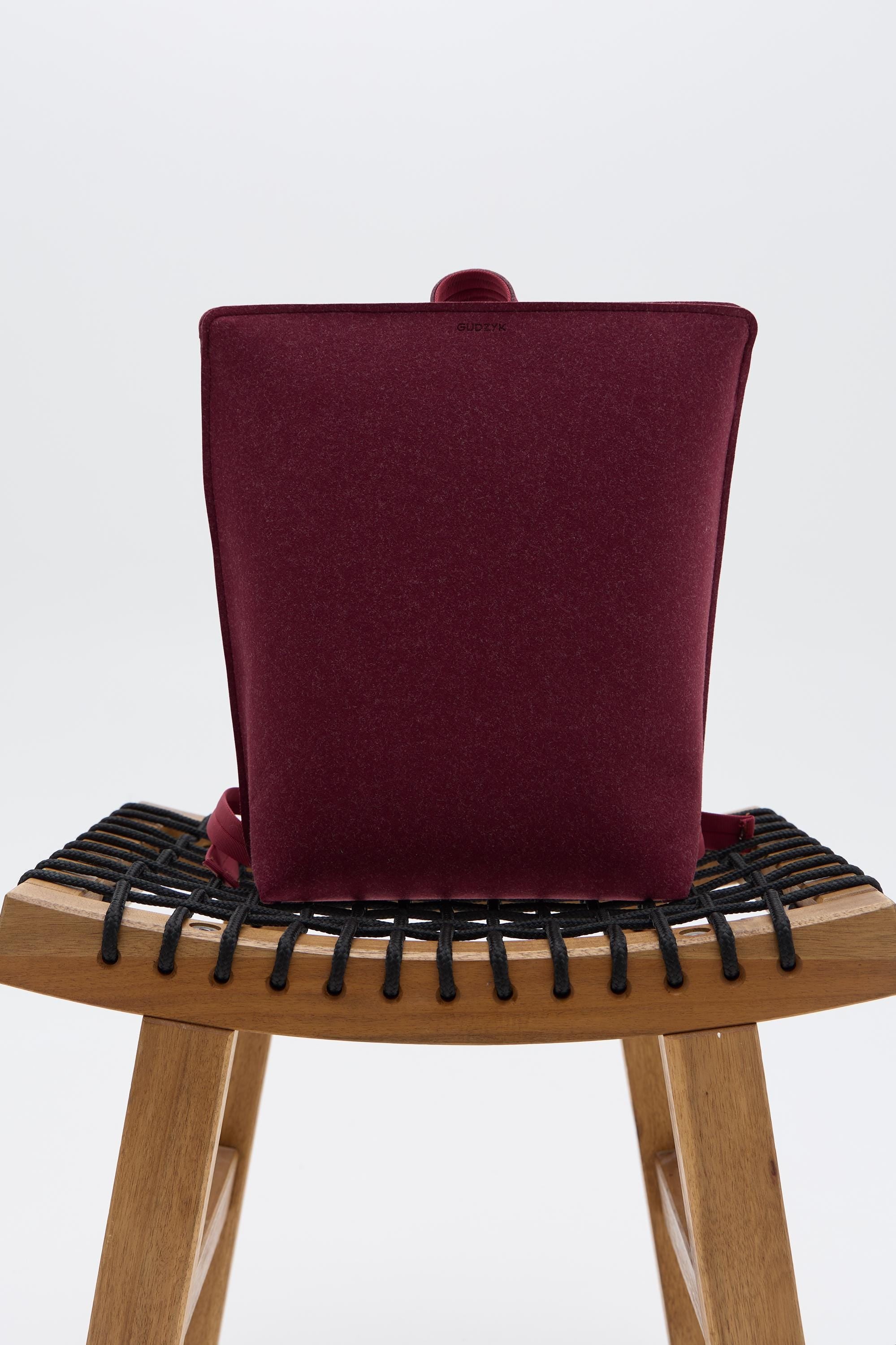 Maroon backpack on a chair 