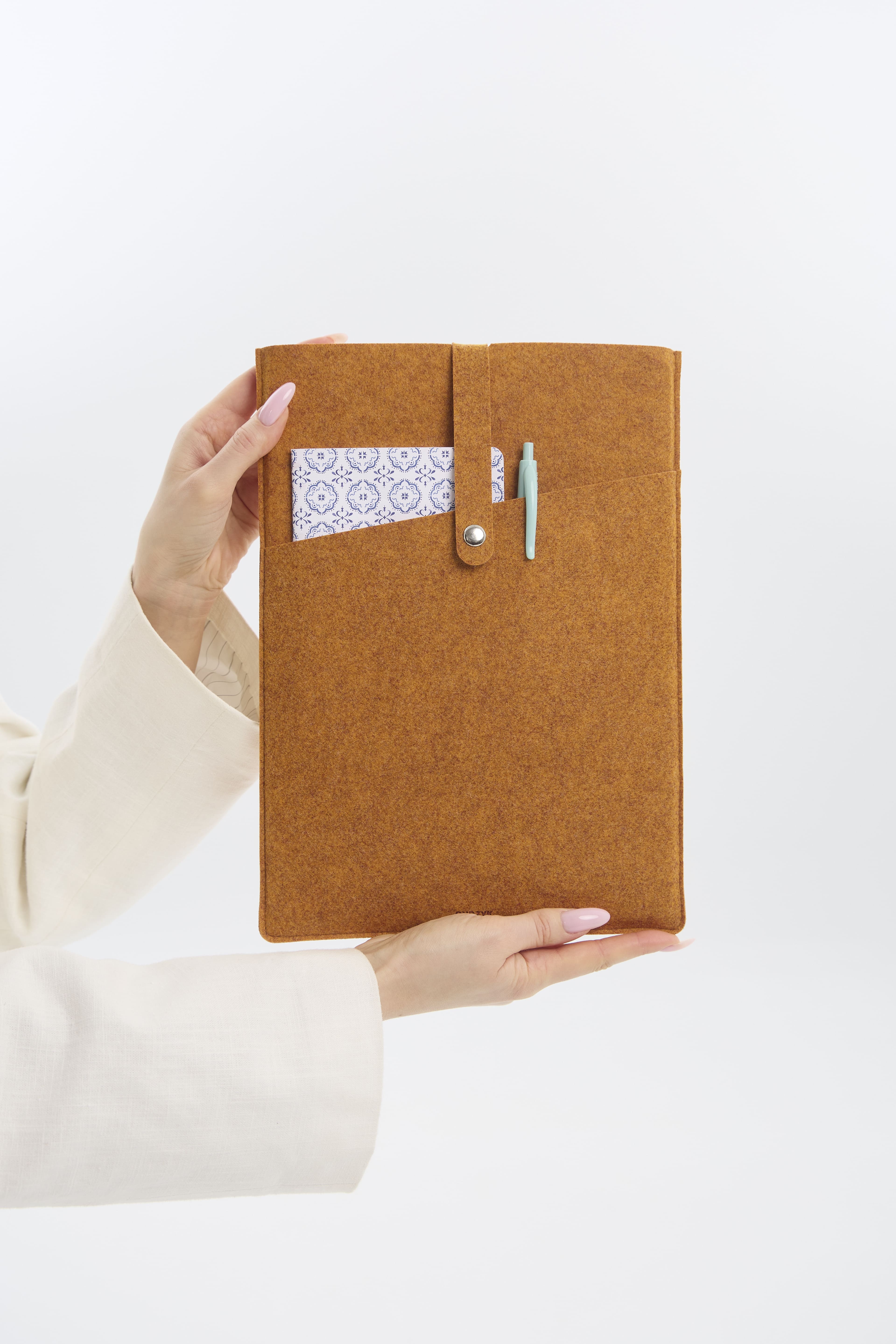 Orange felt laptop case held by a person on a white background