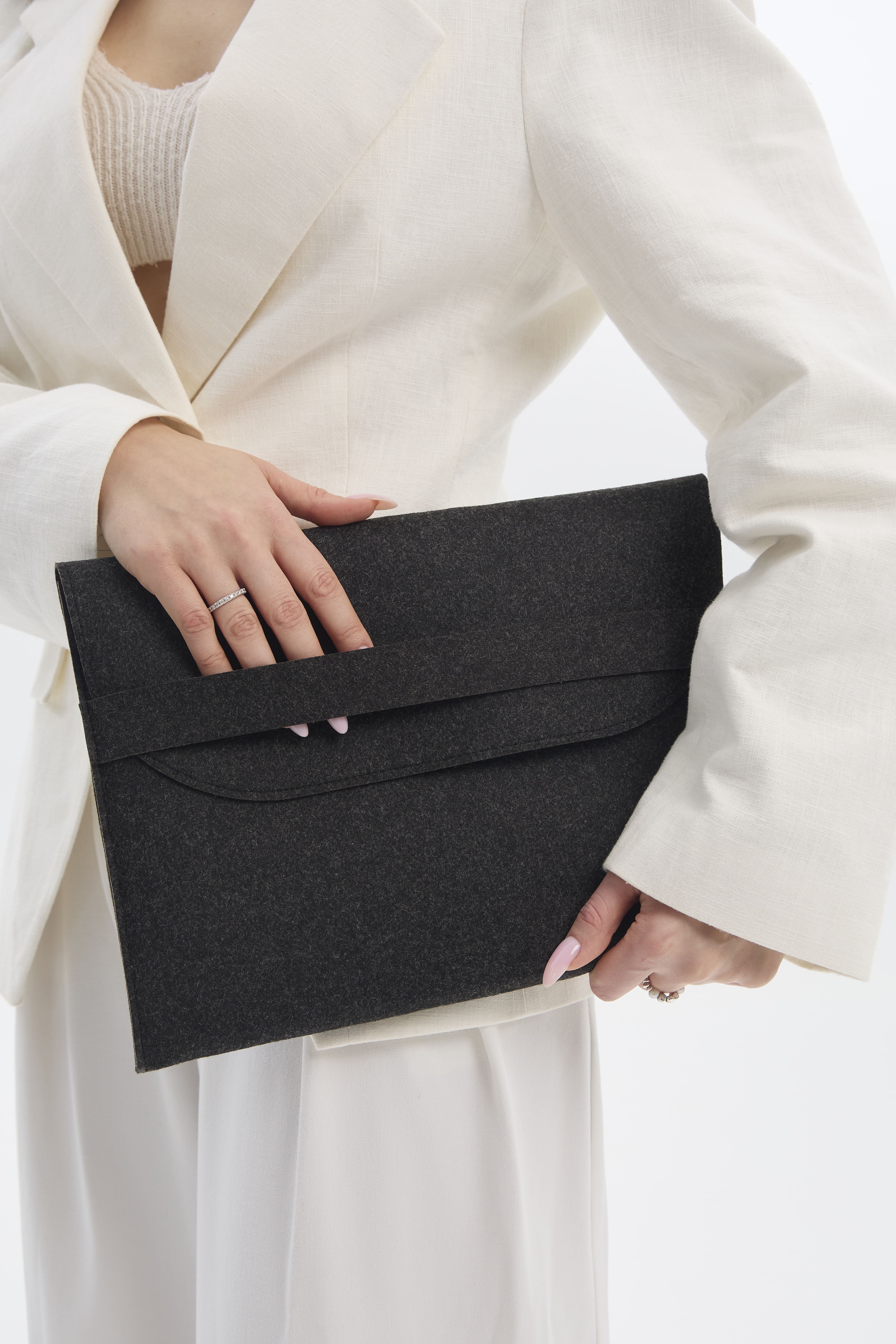 Person holding a black sleeve bag against a white background