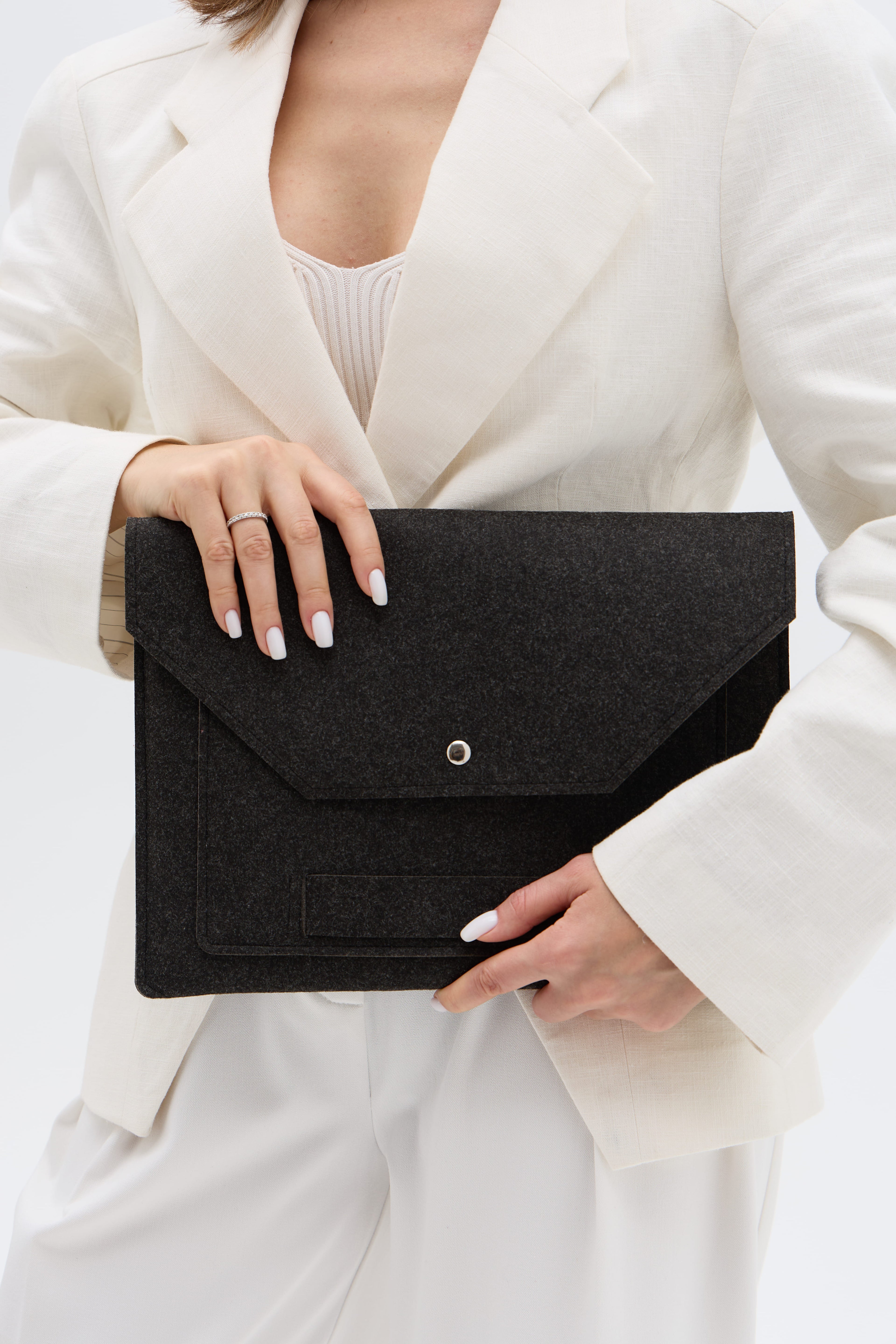 Person holding a black case against a white background