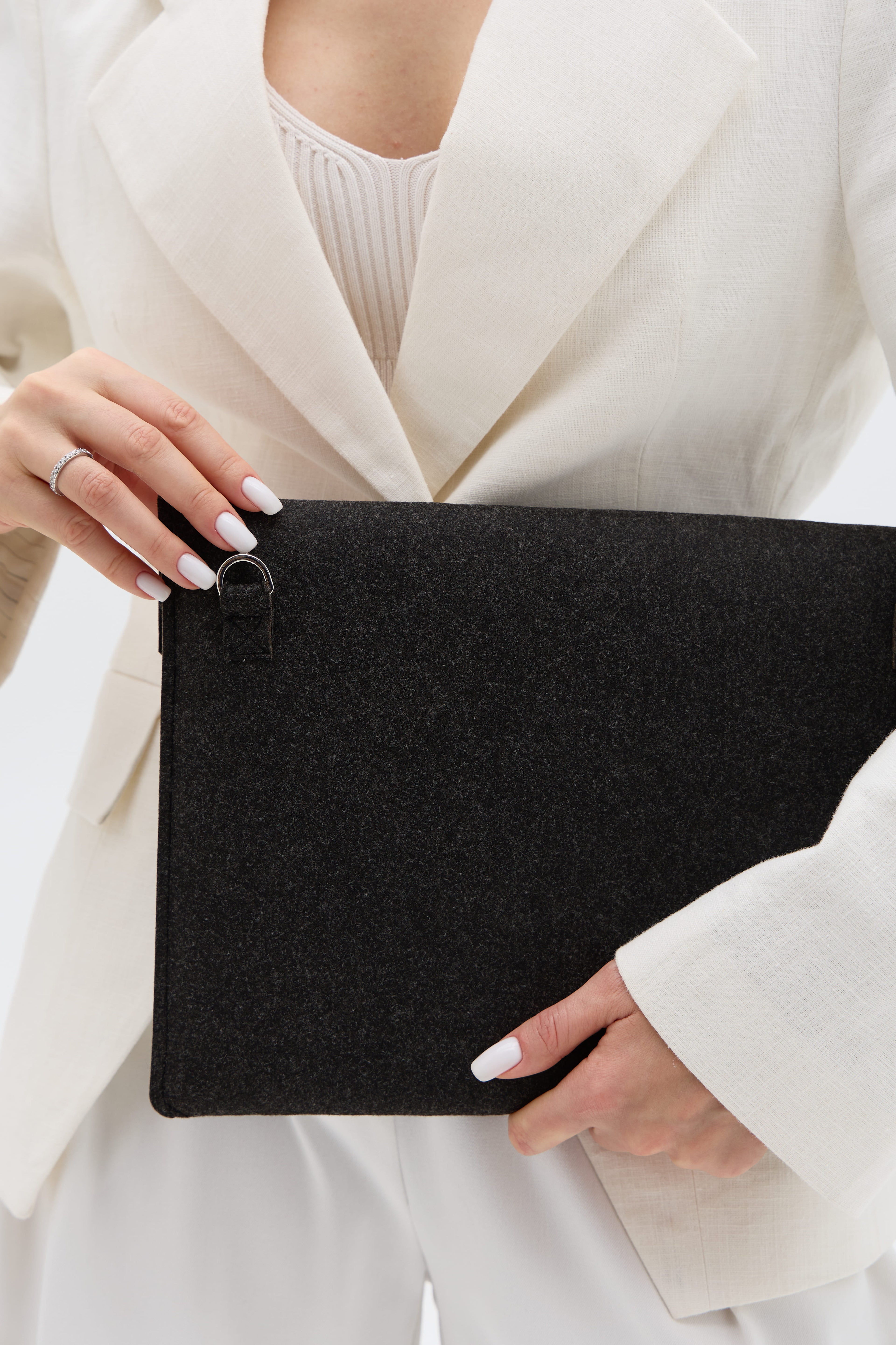 Person holding a black laptop bag with a white outfit
