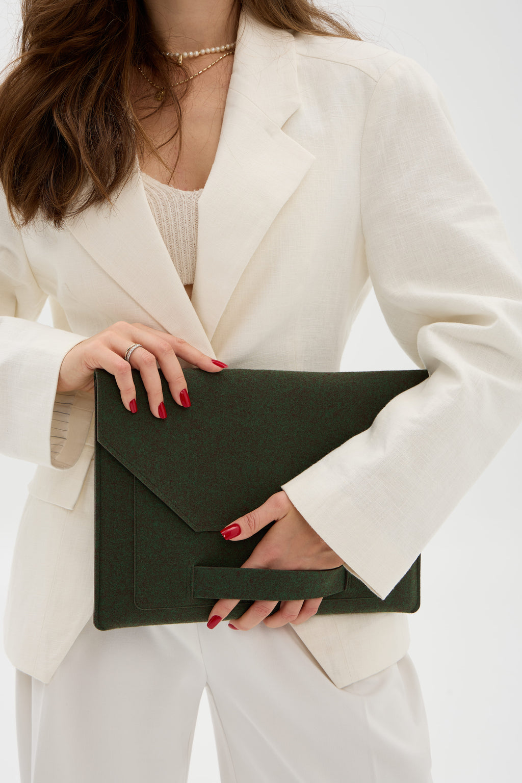 Person holding a dark green case against a white background