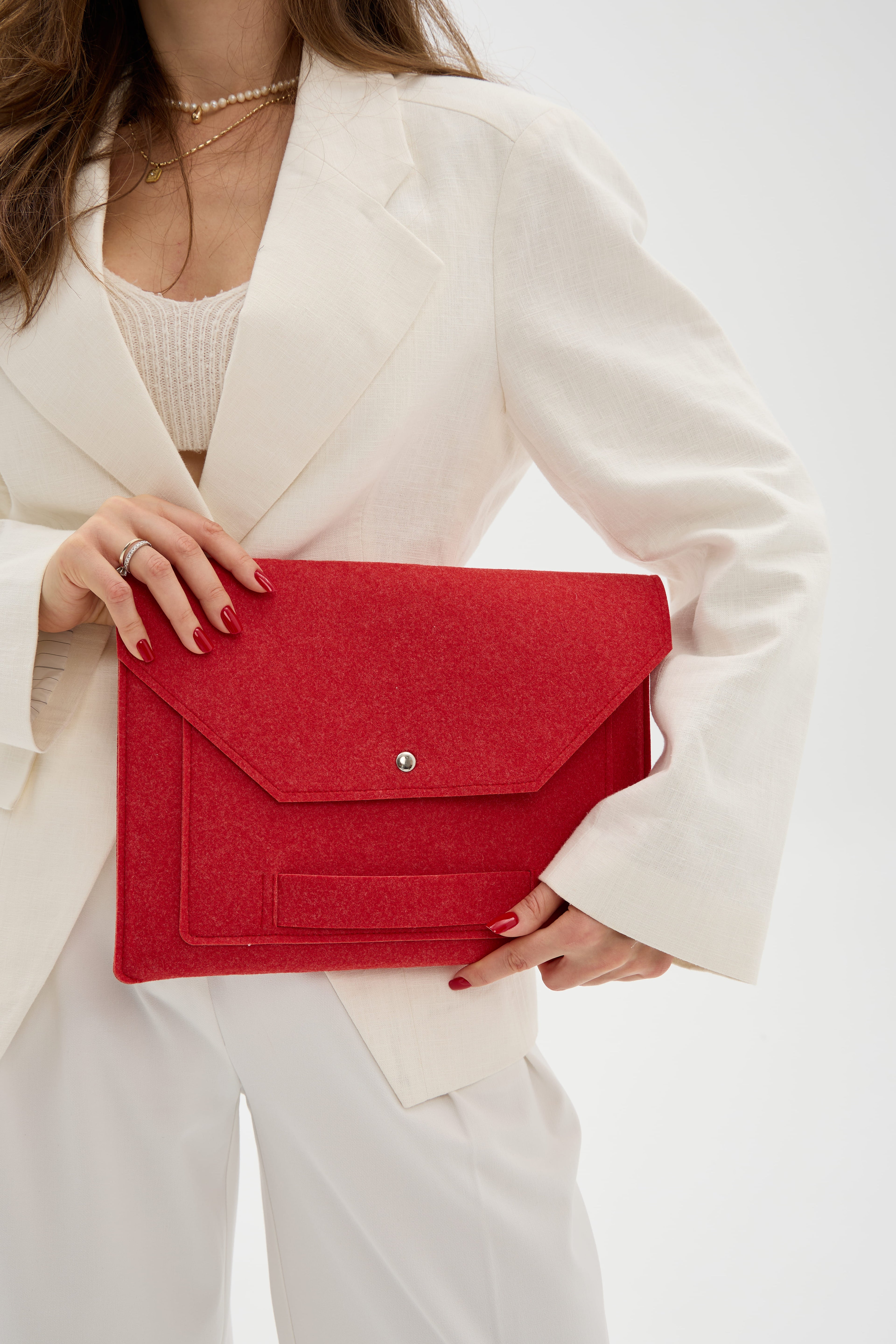 Person holding a red laptop bag against a white background