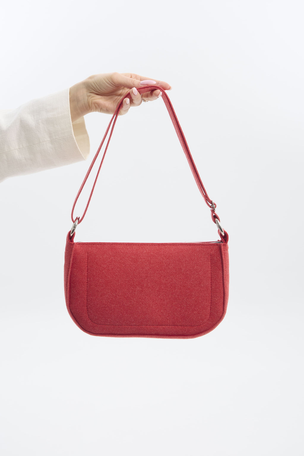 Red handbag held by a person against a white background