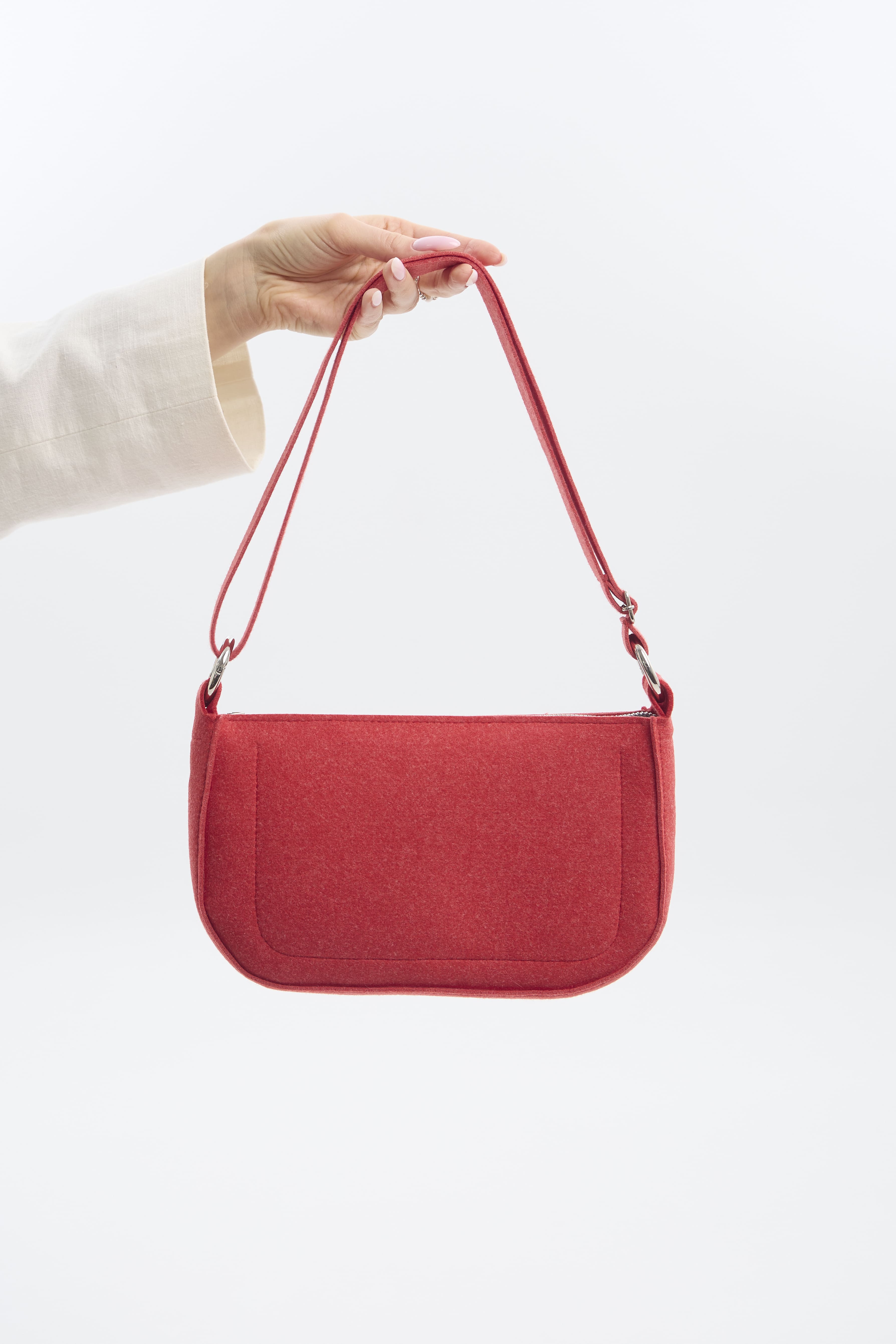 Red handbag held by a person against a white background