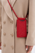 Red phone pouch hanging from a beige coat