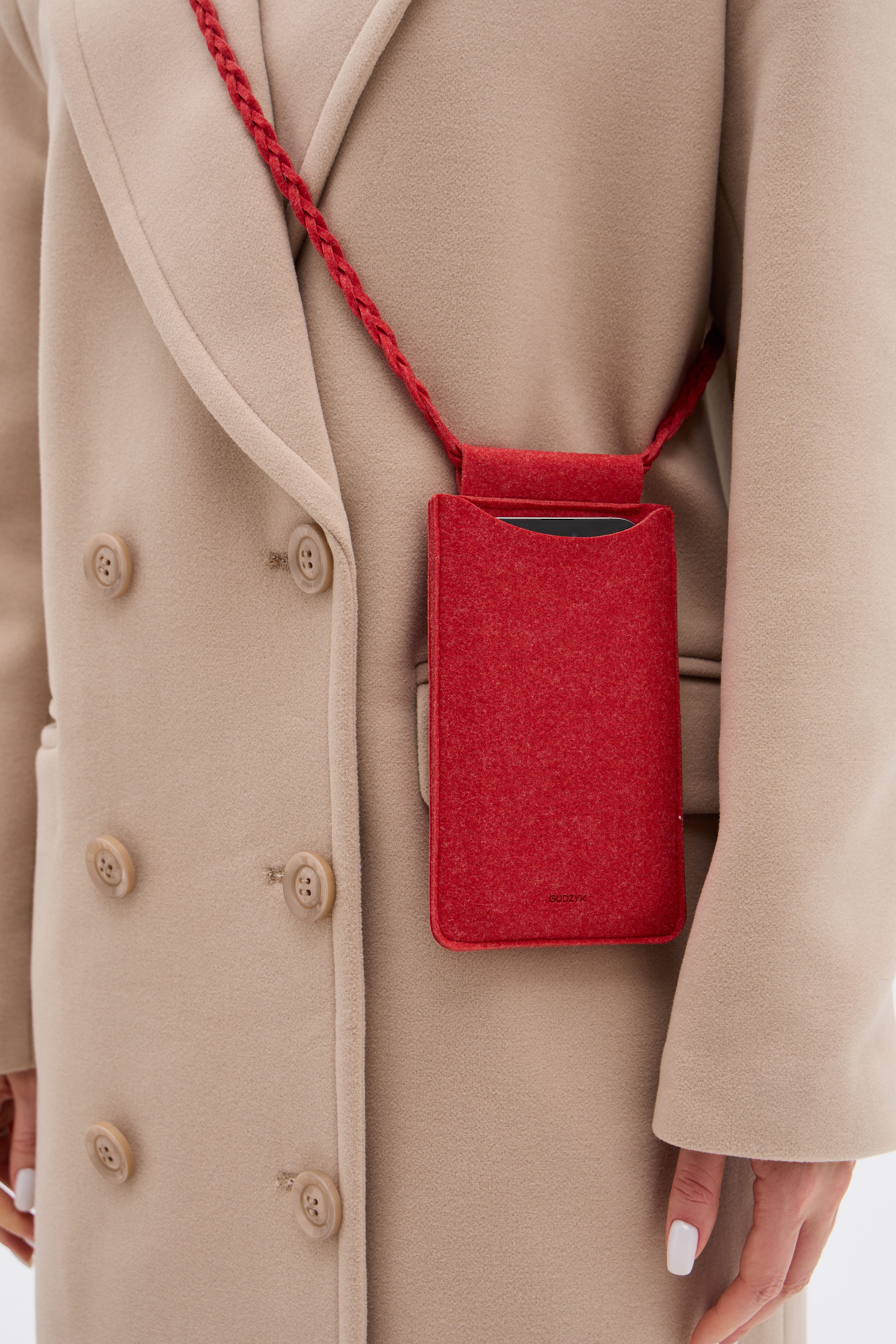 Red phone pouch hanging from a beige coat