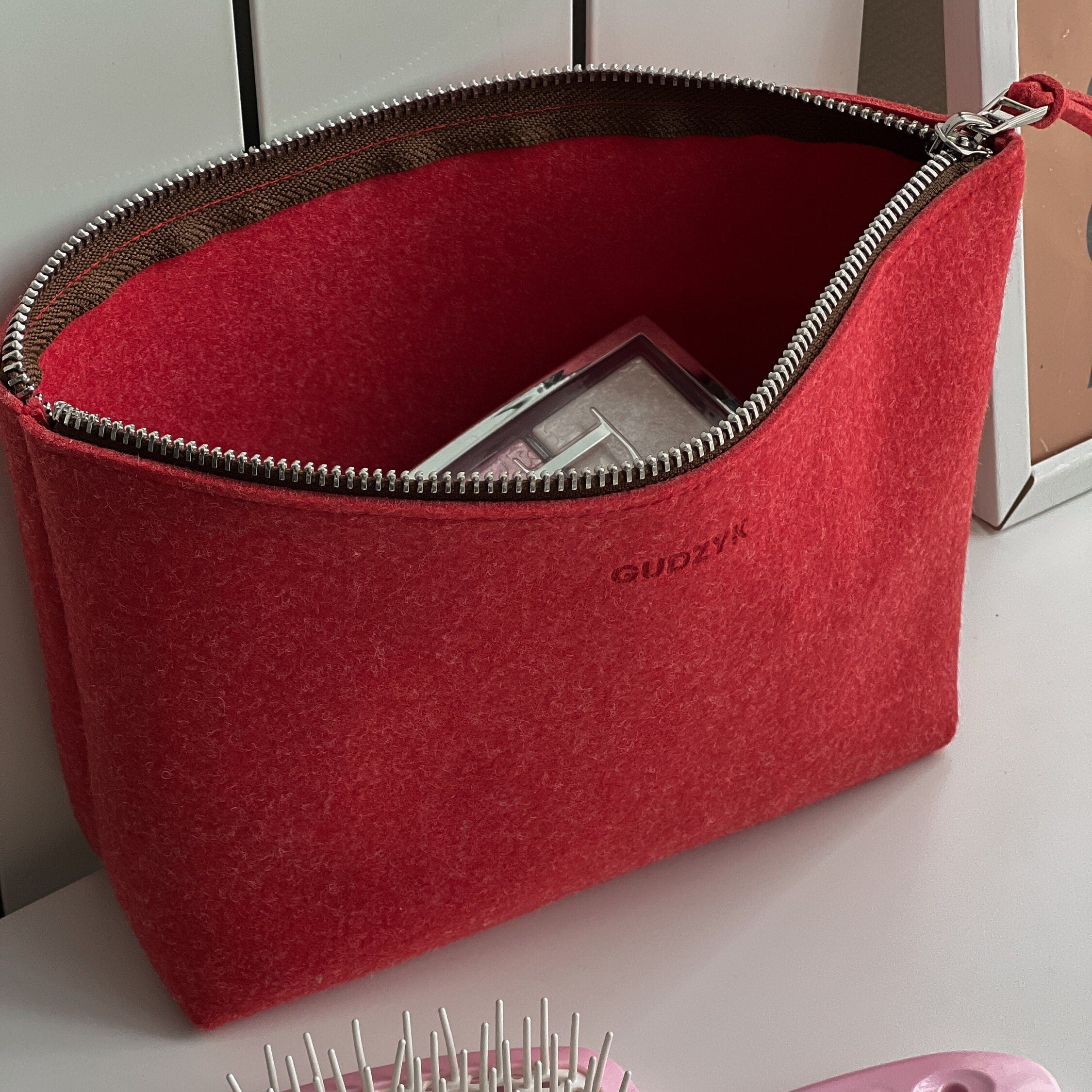 Red pouch with a brand logo on a white surface