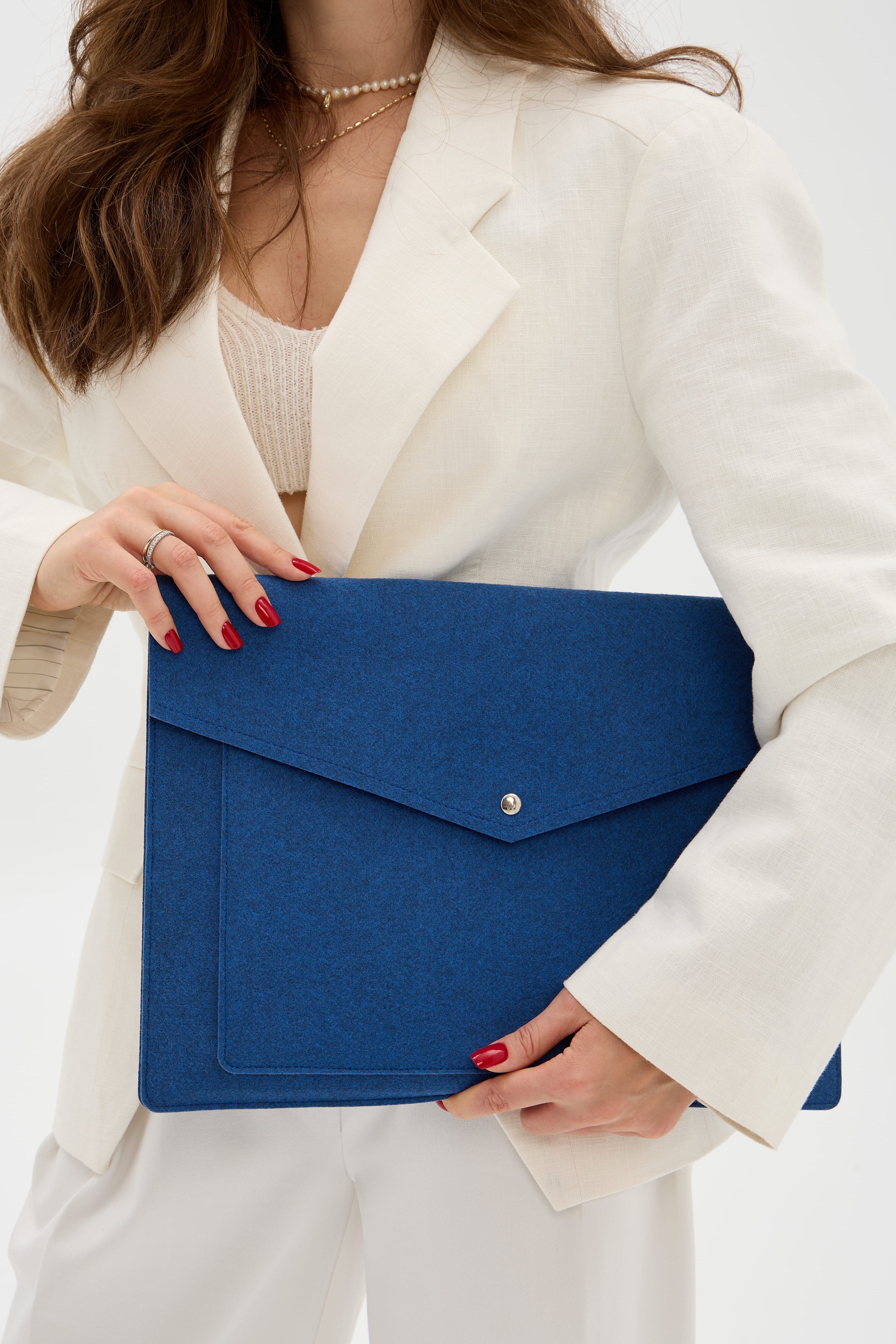 Person holding a blue laptop bag against a white background