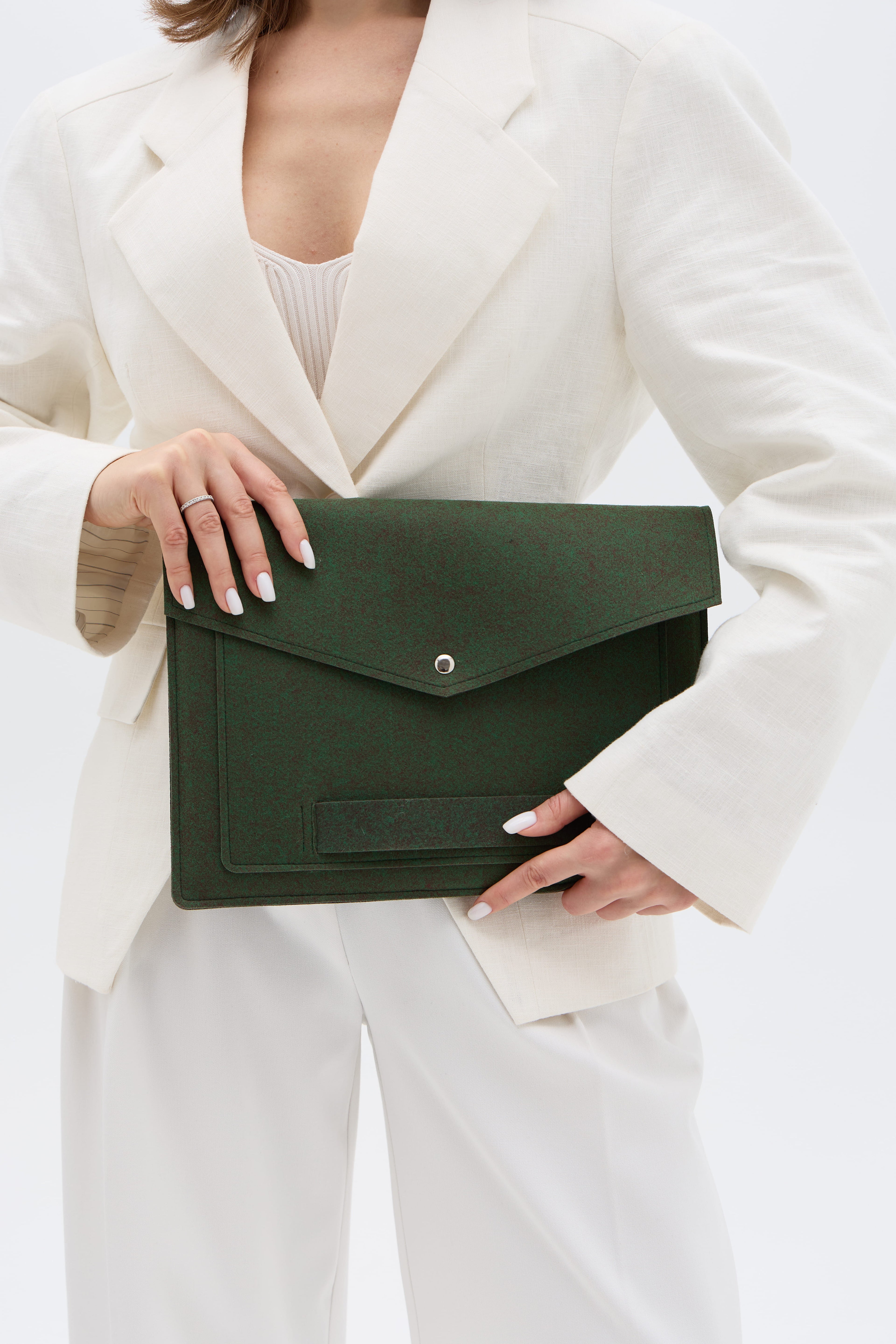 Person holding a green laptop bag against a white background