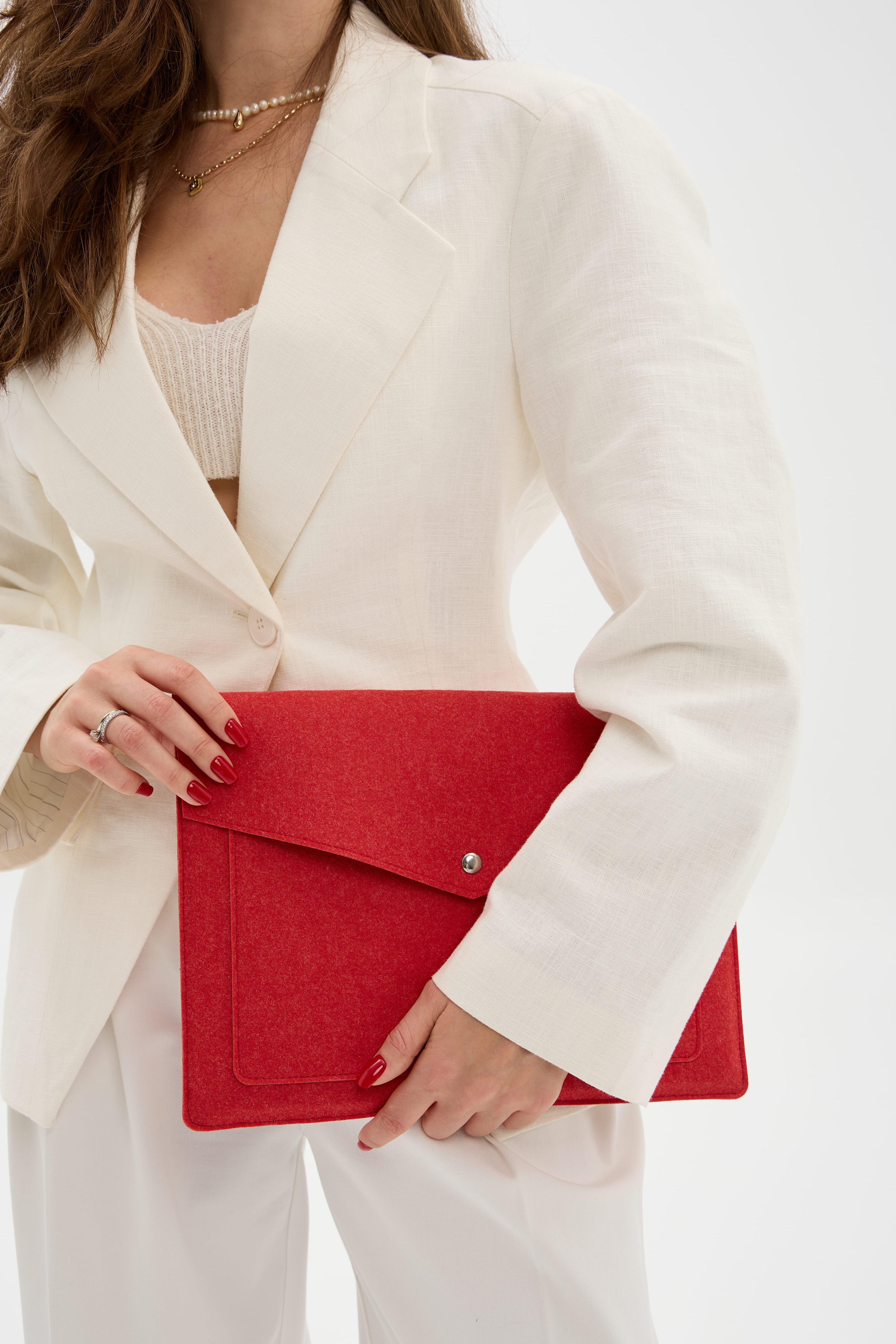 Person holding a red laptop bag against a white background