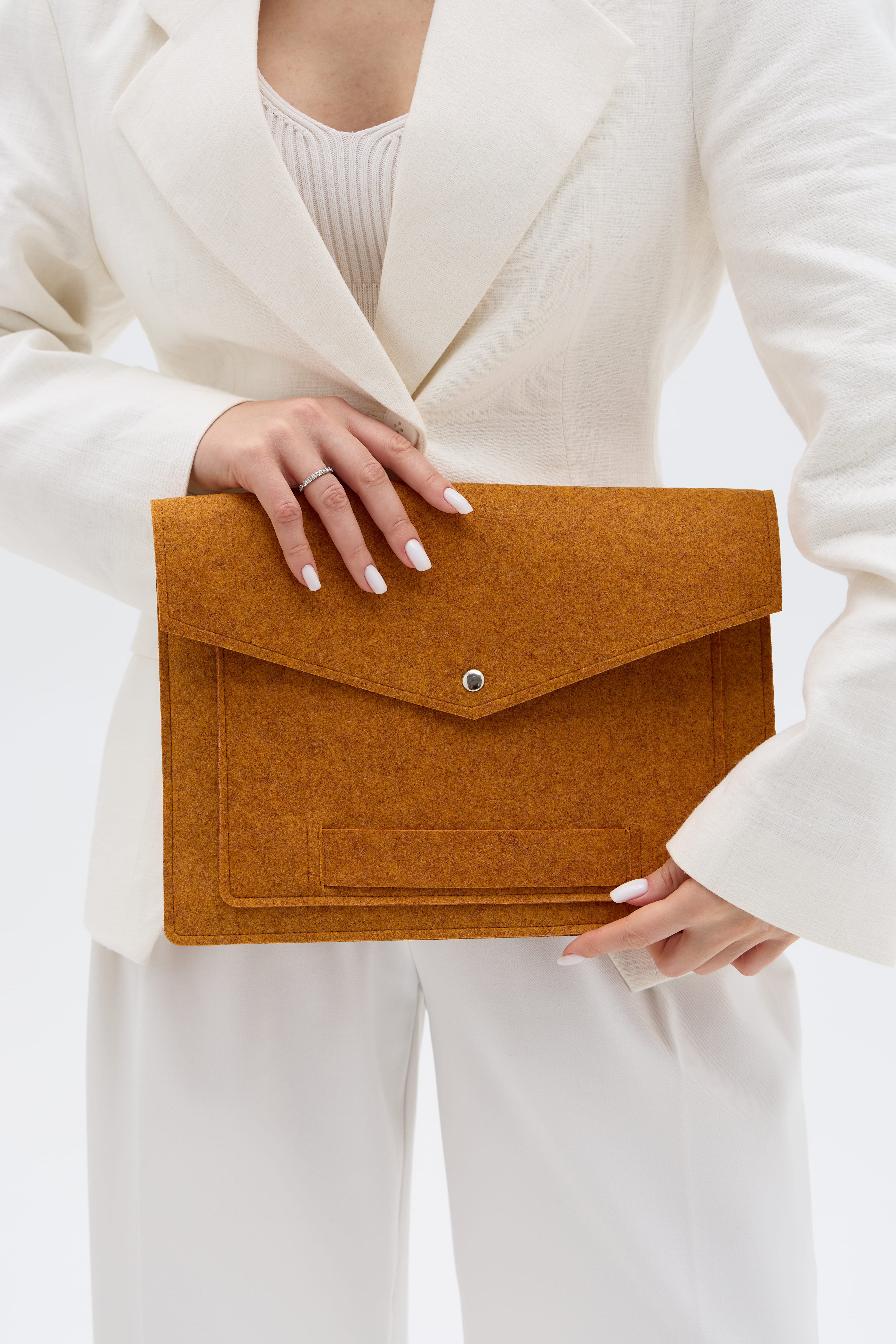Person holding an orange laptop bag against a white background