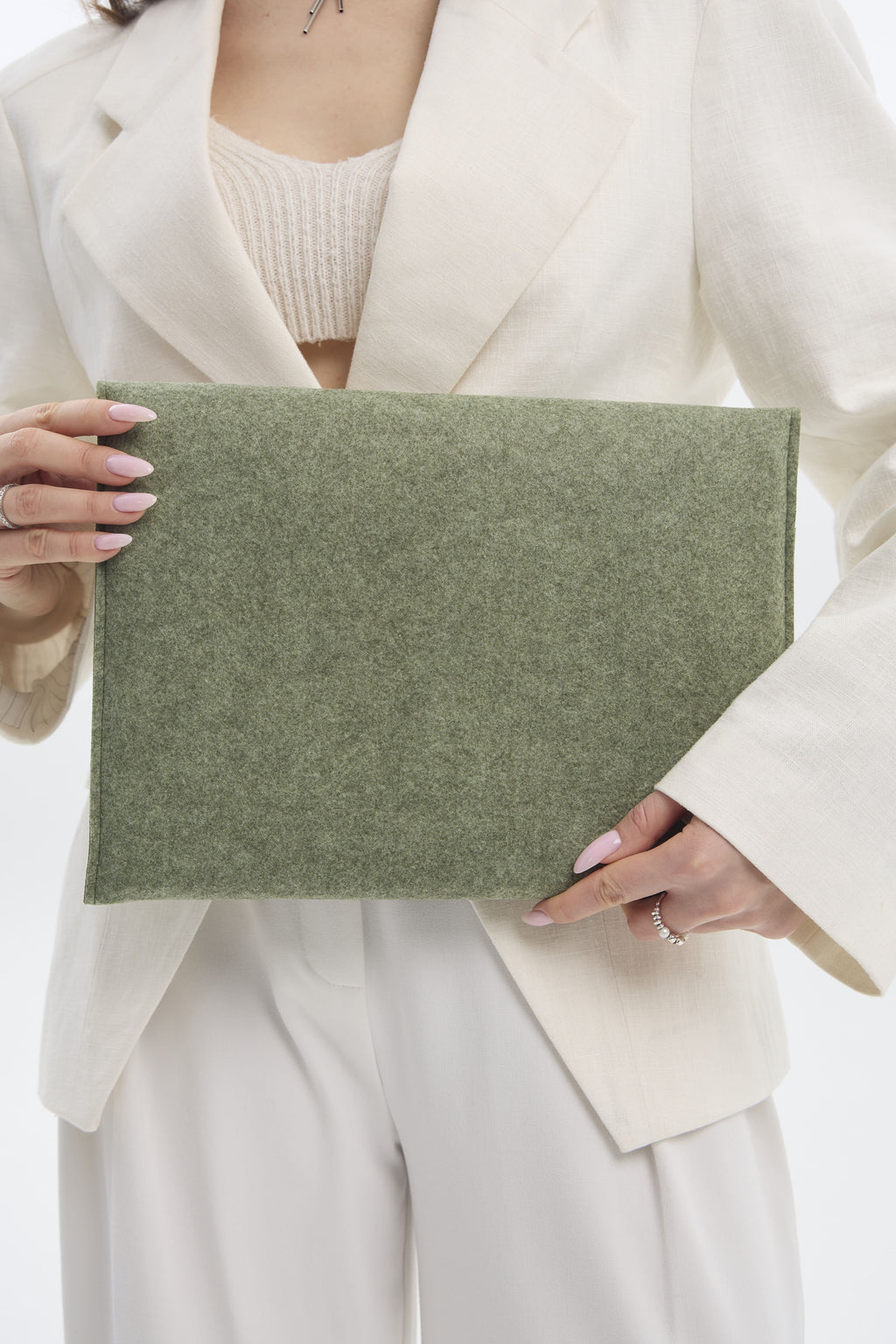 Person holding a green sleeve against a neutral background