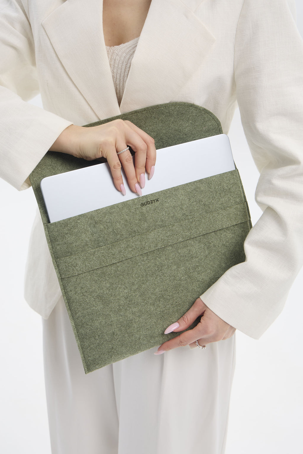 Person holding a green felt sleeve with a white interior
