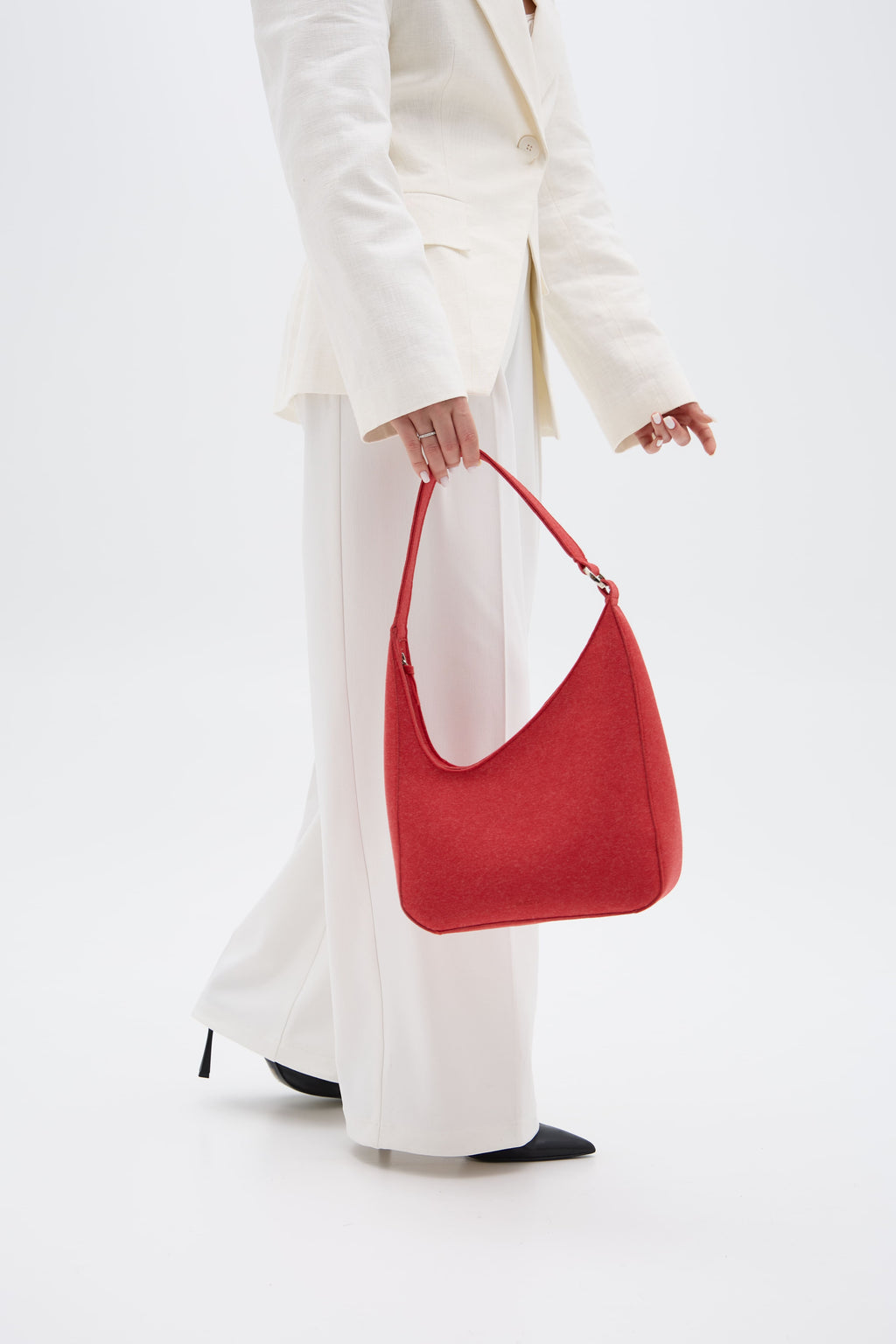 Person holding a red handbag against a white background