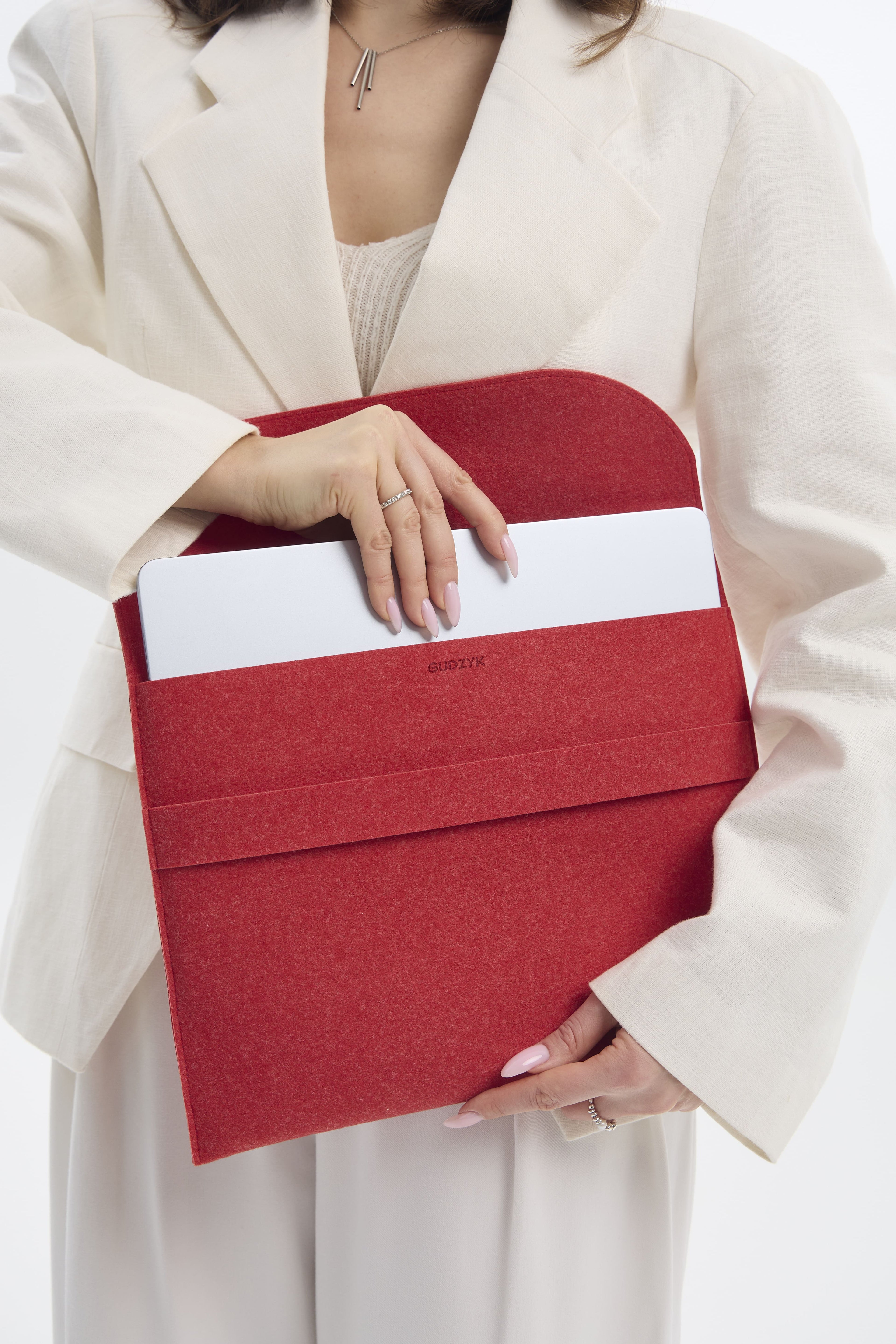 Person holding a red case for laptop against a white background