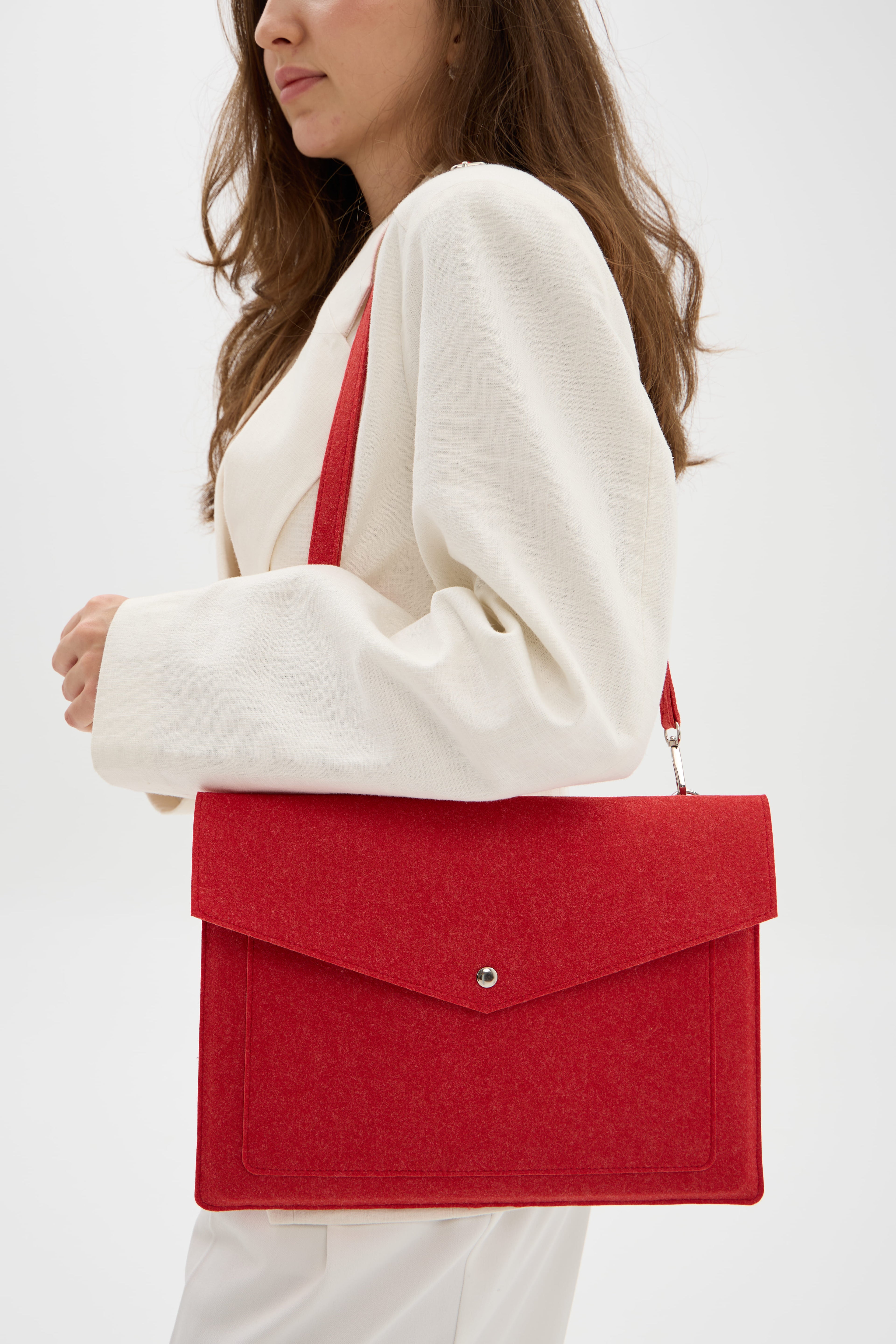 Person holding a red bag against a white background