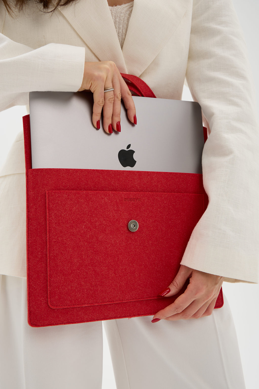 Person holding a red laptop sleeve with an Apple logo