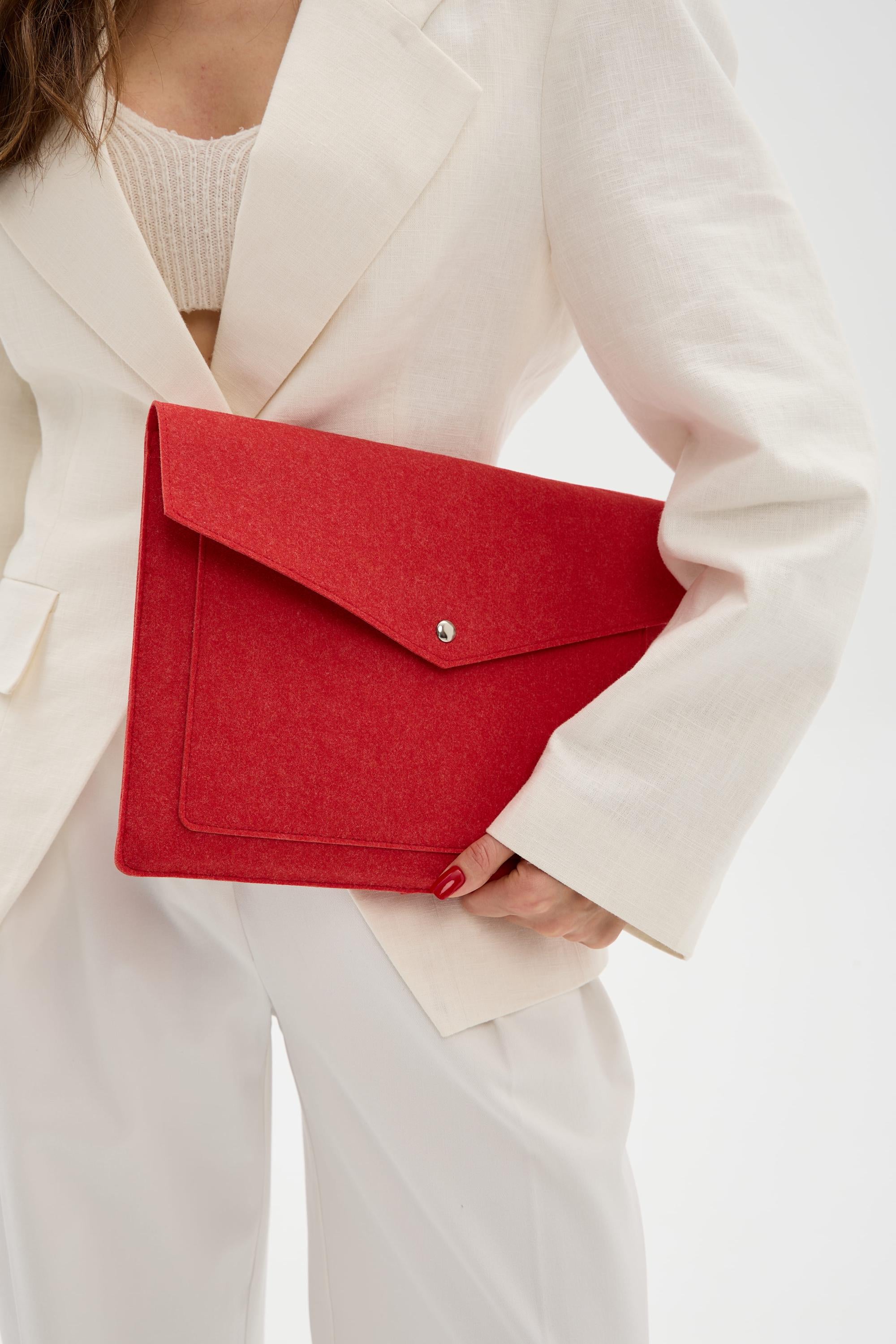 Person holding a red sleeve bag against a white background